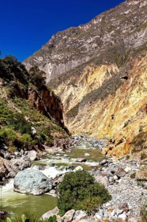 Picturesque river landscape between steep rock faces under clear sky, The landscape of the Colca