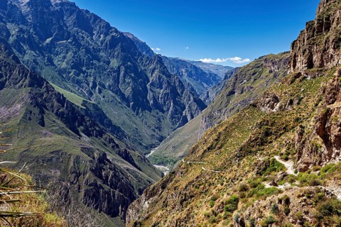 High mountains with deep gorges and rugged cliffs under a blue sky, the landscape of Colca Canyon