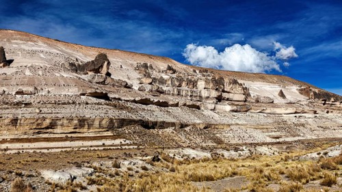 Stratified rock formations with blue sky and sparse clouds, The Andean highlands of Peru