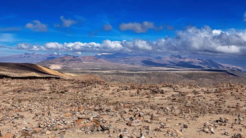 Stone area under blue sky with rising clouds in the distance, The highlands of the Andes of Peru