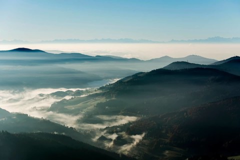 View from Belchen heading south of Wiesental and the Swiss Alps, morning atmosphere with fog in