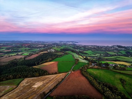 Sunset of Devon Farms and Fields over Berry Pomeroy from a drone, Totnes, England, United Kingdom