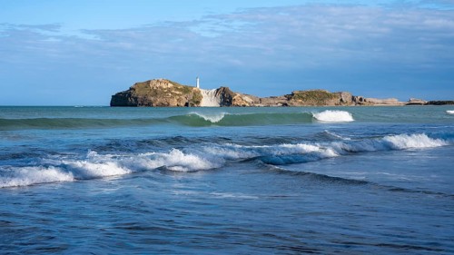 Castlepoint Beach and Castlepoint Lighthouse, ocean, waves, surf, sandy beach, rocks. Castlepoint,