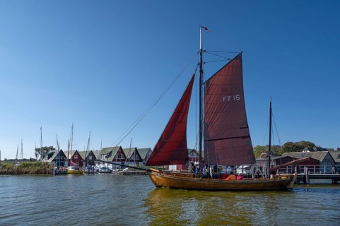 Zeesboot, former historic fishing boat, leaves the port of Ahrenshoop, blue sky, Darß,