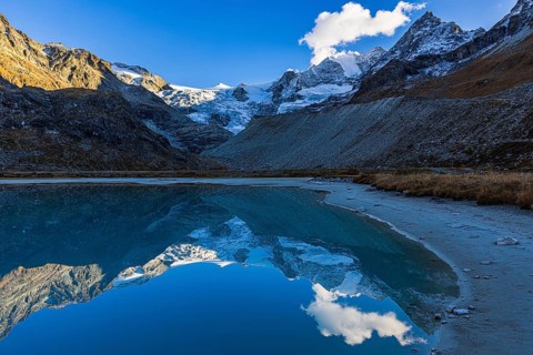 The Moiry glacier and mountain peaks are reflected in Lac de Chateaupre, Val d'Anniviers, Valais