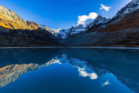 The Moiry glacier and mountain peaks are reflected in Lac de Chateaupre, Val d'Anniviers, Valais