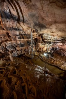 Stalactites and stalagmites, rock formations in a stalactite cave with water basin, Grotta del