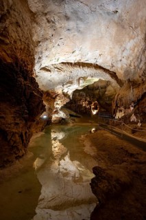 Stalactites and stalagmites, reflection in a small underground lake, rock formations in a