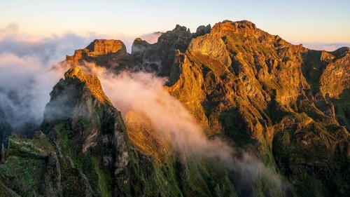 Sunrise at Pico do Arieiro, clouds of fog pass over mountain peaks, hiking trail PR1, Madeira,