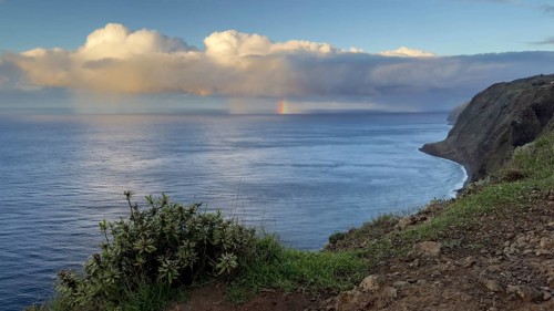Sunset, rainbow over sea, at Farol da Ponta do Pargo lighthouse, west coast, Madeira, Portugal