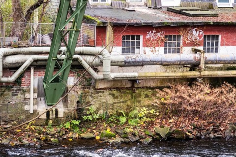 District heating pipeline in front of old industrial buildings on the banks of the Wupper,