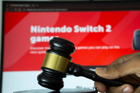 Dhaka, Bangladesh- 20 June 2025: A hand holds a gavel in front of a computer screen displaying