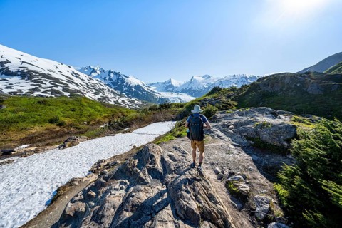 Hikers on the Portage Pass Trail, snow-covered mountains and Portage Glacier glaciers, near