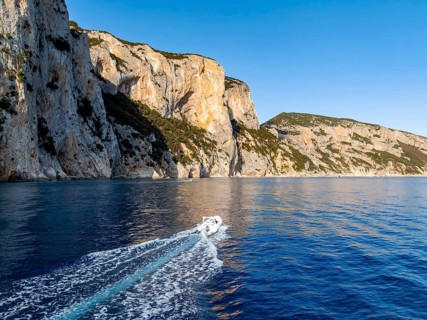 Motorboat rides on picturesque rocky coast ImmorgenLicht, cliffs, Golfo di Orosei, Baunei,