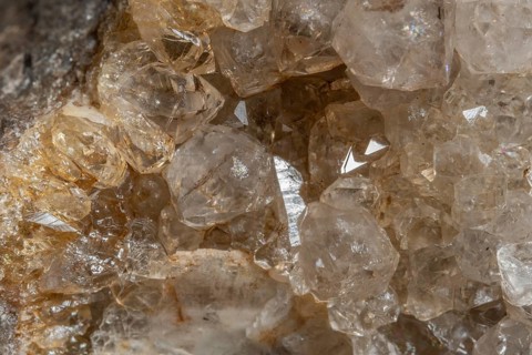 Bright, square crystals are visible on a piece of rock. The light underlines their structure and
