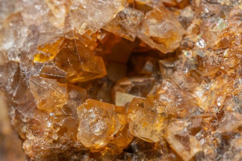 Shiny crystals of blue and orange color can be seen in this mineral formation. They are sparkling
