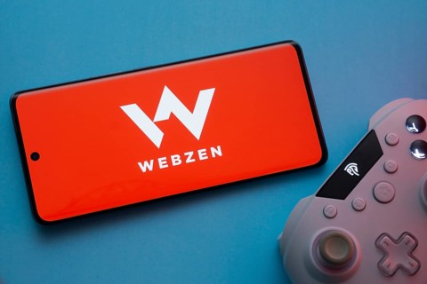 Dhaka, Bangladesh- 22 Mar 2025: Smartphone with Webzen logo, game controller, and earbuds on a
