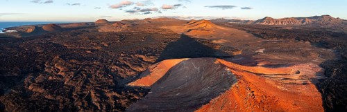 Picturesque volcanic landscape in evening light, red volcano Montaña Bermeja between lava fields,