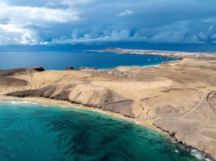 Coast with Playa Caleta del Congrio beach and blue sea, arid landscape of Los Ajaches Natural Park,