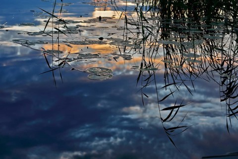 Spring atmosphere with cloudy skies and sunshine over a quiet river, Peenetal nature park Park,