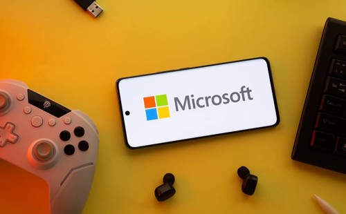 Dhaka, Bangladesh- 23 Mar 2025: Smartphone with Microsoft logo, game controller, and earbuds on a