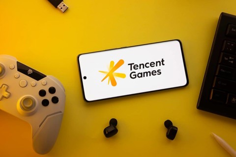 Dhaka, Bangladesh- 23 Mar 2025: Smartphone with Tencent Games logo, game controller, and earbuds on
