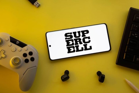 Dhaka, Bangladesh- 23 Mar 2025: Smartphone with Supercell logo, game controller, and earbuds on a