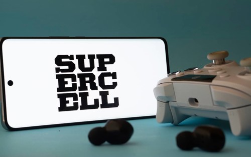 Dhaka, Bangladesh- 23 Mar 2025: A smartphone with a Supercell icon next to a controller and earbuds