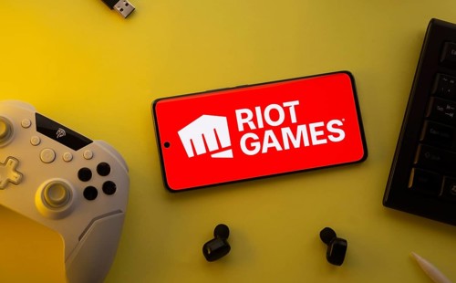 Dhaka, Bangladesh- 23 Mar 2025: Smartphone with Riot Games logo, game controller, and earbuds on a