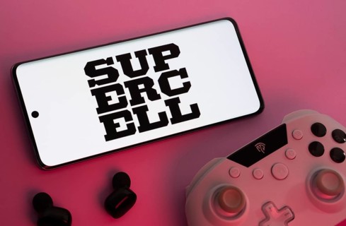 Dhaka, Bangladesh- 22 Mar 2025: Smartphone with Supercell logo, game controller, and earbuds on a