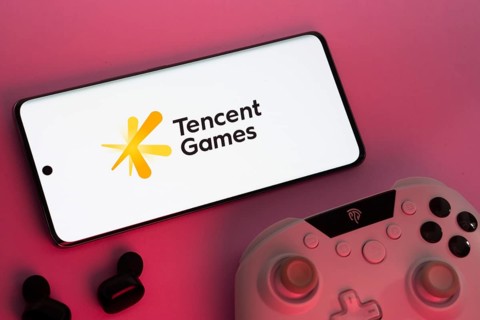 Dhaka, Bangladesh- 22 Mar 2025: Smartphone with Tencent Games logo, game controller, and earbuds on