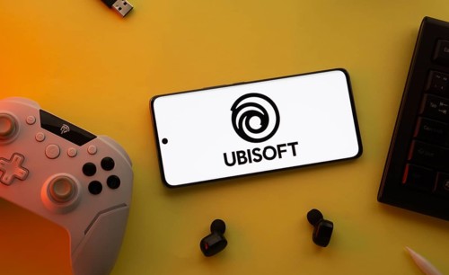 Dhaka, Bangladesh- 23 Mar 2025: Smartphone with Ubisoft logo, game controller, and earbuds on a