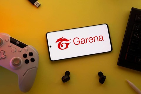 Dhaka, Bangladesh- 23 Mar 2025: Smartphone with Garena logo, game controller, and earbuds on a