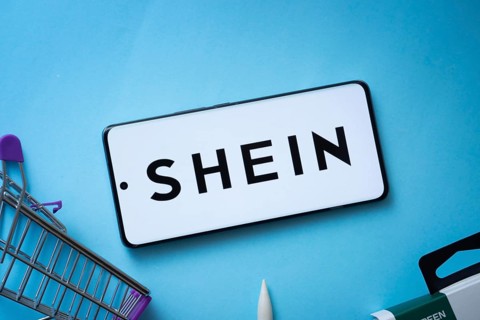 Dhaka, Bangladesh- 03 July 2025: Smartphone displaying SHEIN logo with shopping cart on a blue