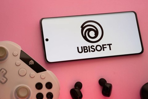 Dhaka, Bangladesh- 22 Mar 2025: Smartphone with Ubisoft logo, game controller, and earbuds on a