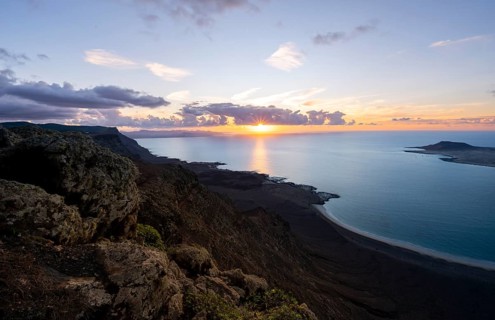 View from steep cliffs to sea and coast with sun stars, Mirador del Porrito viewpoint at sunset,