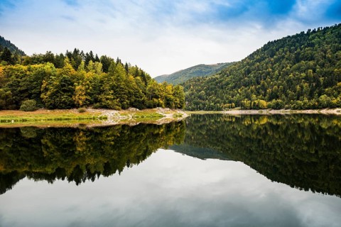 Picturesque mountain lake with water reflections in autumn, Lac de Kruth-Wildenstein, Kruth,