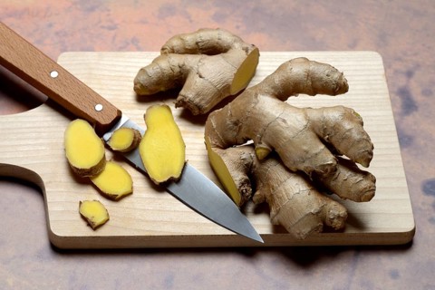 Ginger, ginger root cut with ginger slices on wooden boards