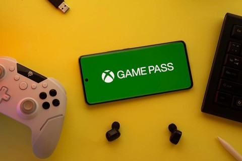 Dhaka, Bangladesh- 15 July 2025: Smartphone with Xbox game pass logo, game controller, and earbuds