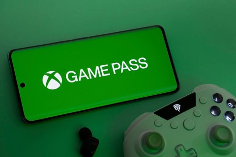 Dhaka, Bangladesh- 15 July 2025: Smartphone with Xbox Game Pass logo, game controller, and earbuds