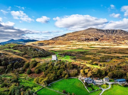 Autumn colours over Castell Dolwyddelan and Eryri Mountains from a drone, Snowdonia, Conwy County
