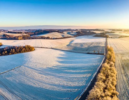 Bird Eye Perspective of Frost Covered Farmland. Seasonal Agricultural Scenery, winter and autumn