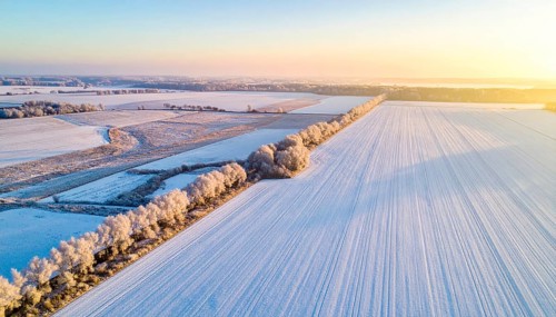 Bird Eye Perspective of Frost Covered Farmland. Seasonal Agricultural Scenery, winter and autumn