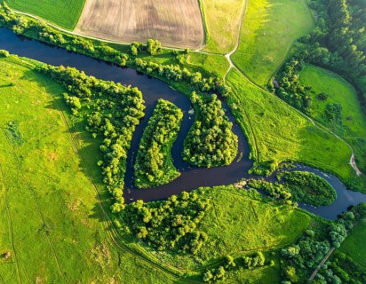 Ecology and environment concept. Green wilderness nature from above. Aerial view on meandering