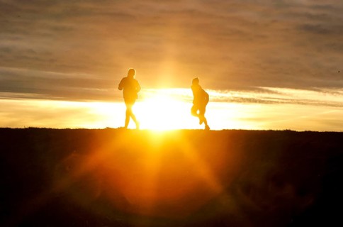Woman and child walk across a dike on the island of Fehmarn at sunset, 13.10.2025, Fehmarn,