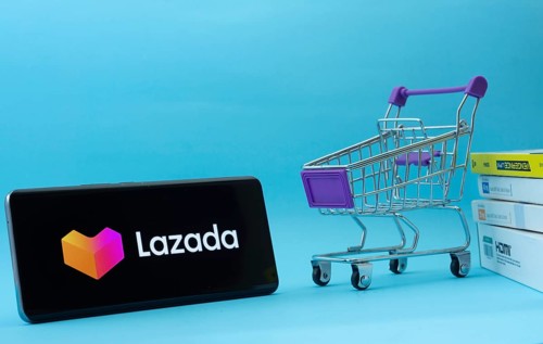 Dhaka, Bangladesh- 03 July 2025: Smartphone with Lazada logo next to a small shopping cart and