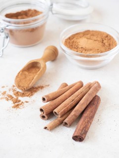 Aromatic cinnamon cassia sticks, ground powder, and a scoop for cooking and baking