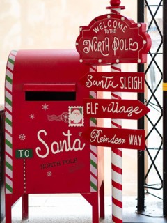 Festive red christmas mailbox and north pole signpost for sending letters to santa claus