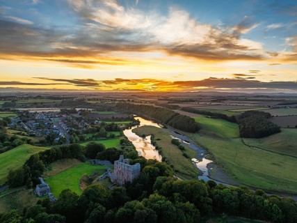 Sunset over Norham Castle and River Tweed from a drone, Norham, Northumberland, England, United