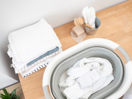 Eco-friendly laundry preparation featuring natural soap, brush, and folded clothes on a wooden